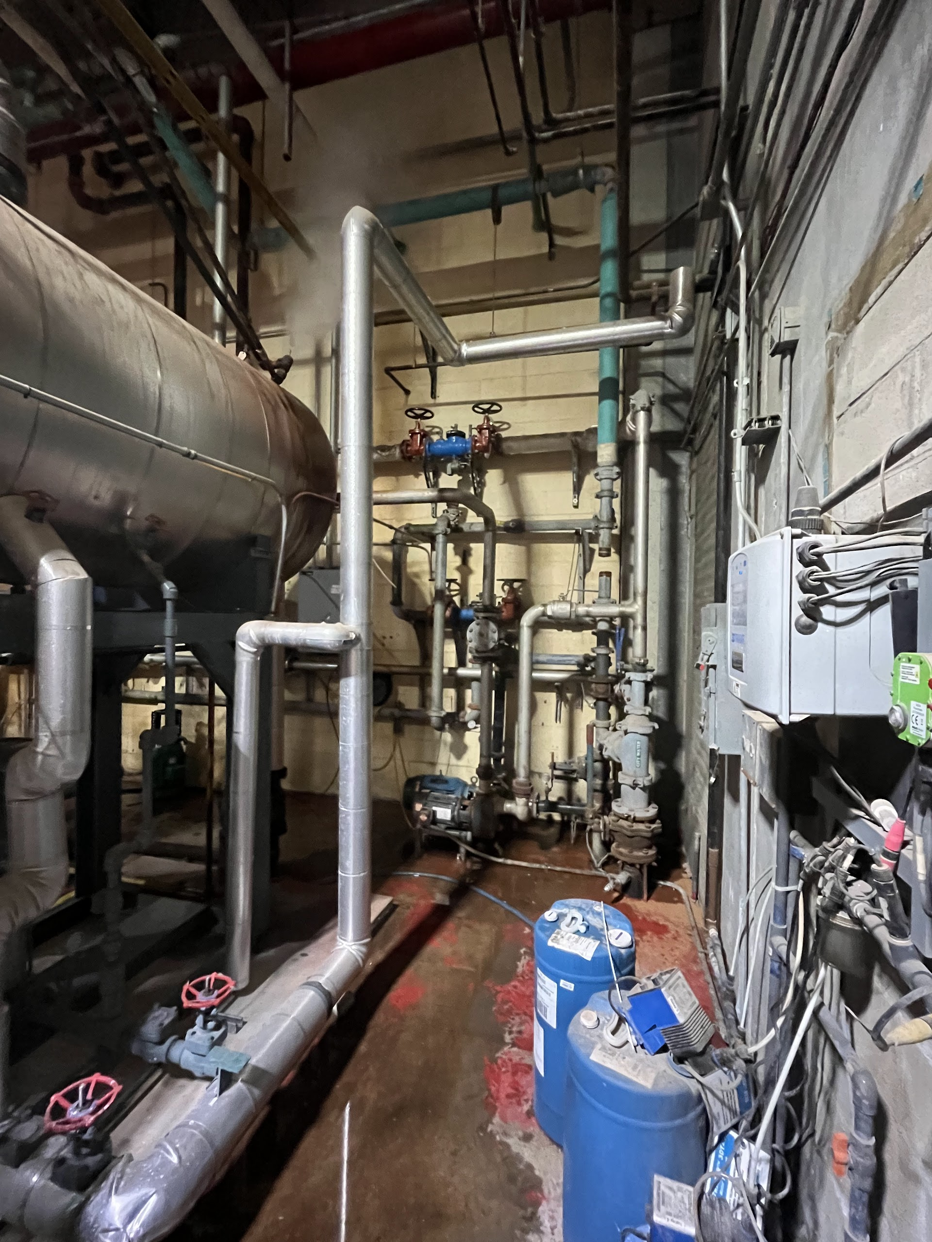 Commercial mechanical room with insulated piping, valves, and equipment.