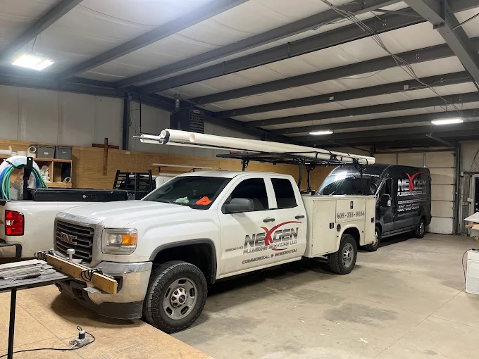 NexGen Plumbing Services trucks parked inside the company shop.
