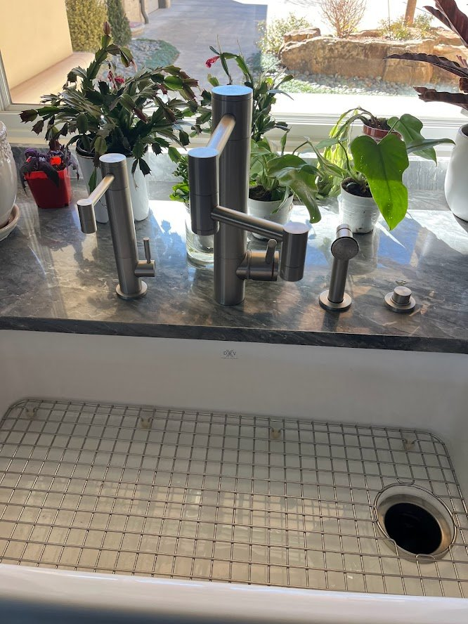 Workstation sink with a modern faucet and fitted basin rack.